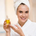 A girl holds the argan oil in her hands.