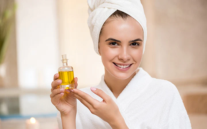 A girl holds the argan oil in her hands.