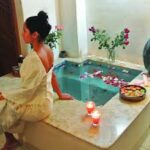 A girl is sitting beside the bathtub tub ready to take the special Moroccan bath Doha.
